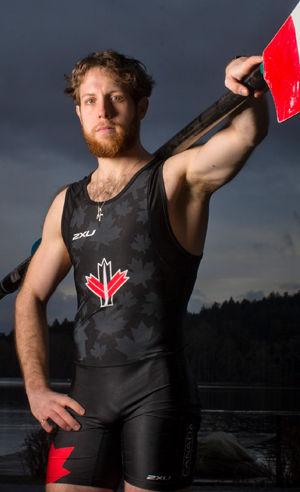 Paralympic athlete Andrew Todd holding an oar across his shoulders. 